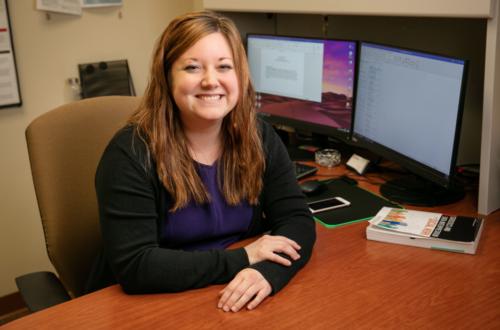 Rachel Garthe seated at desk with computers in background