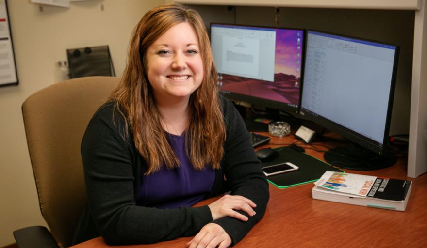 Rachel Garthe seated at desk with computers in background