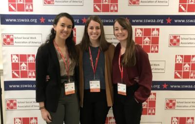 students standing in front of banner at SSWAA conference 