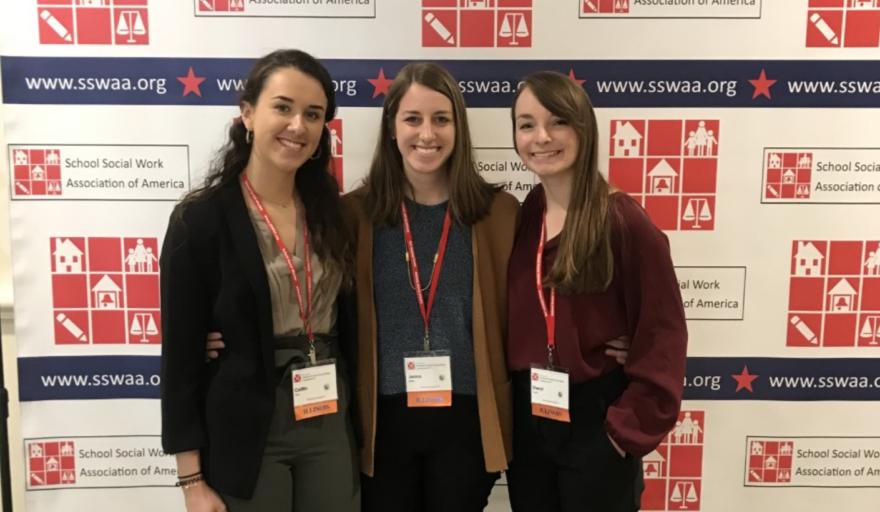 students standing in front of banner at SSWAA conference 