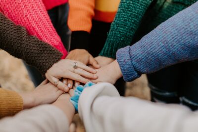 image of students with their hands together in a circle