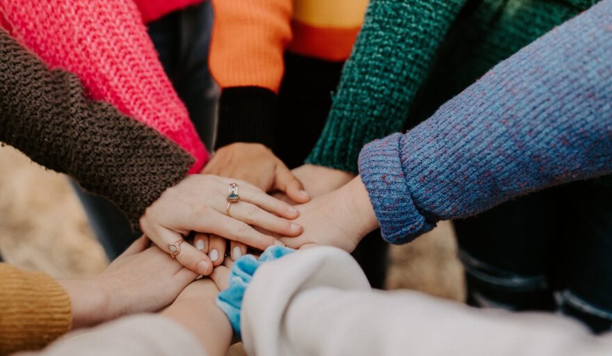 image of students with their hands together in a circle