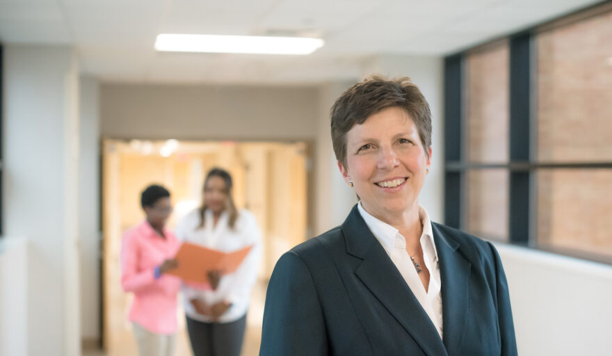 Dr. Janet Liechty standing in hallway of hospital with team members in the background