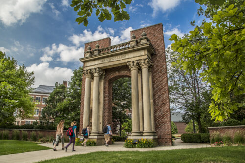 student walking under hallene gateway on urbana campus