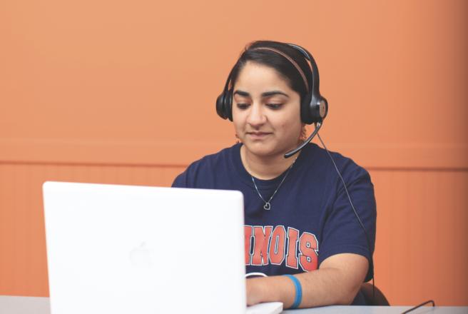 student with headset using laptop