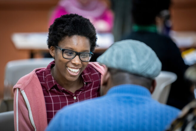 image of student smiling and speaking to another person