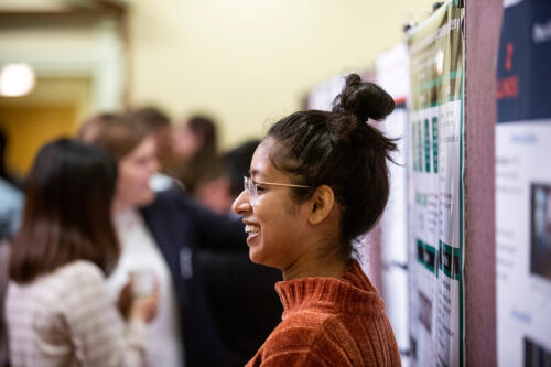 student standing next to poster presentation