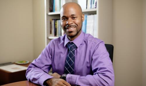 headshot of Ryan Wade at desk