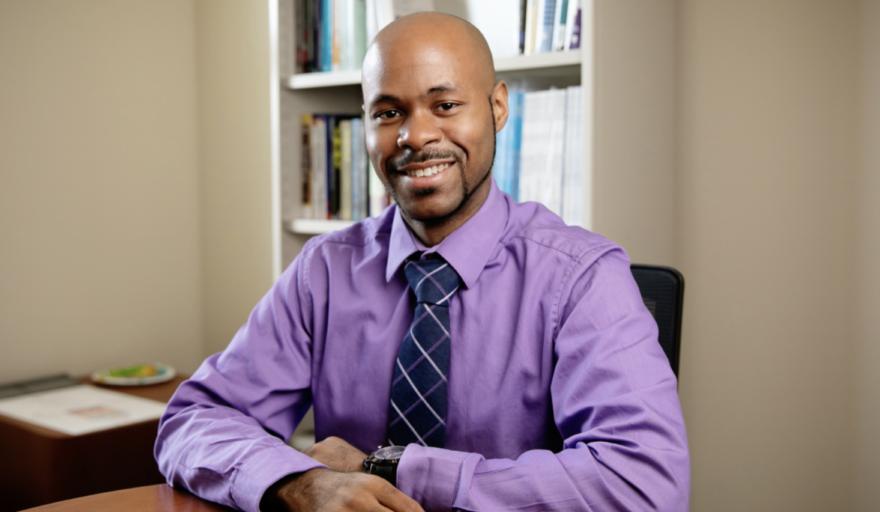 headshot of Ryan Wade at desk