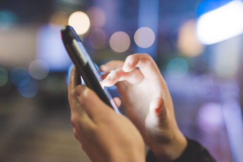 close up of hands using cell phone 