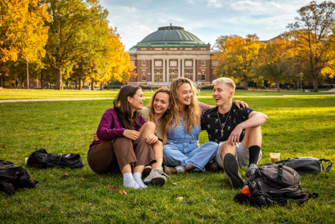 students sitting and laughing on quad