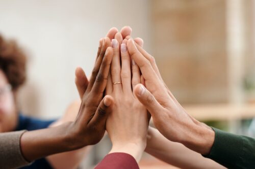 Hands high fiving: teamwork