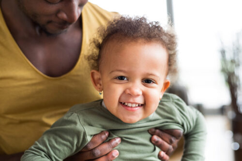 Unrecognizable Father At Home With His Adorable Daughter In His Arms