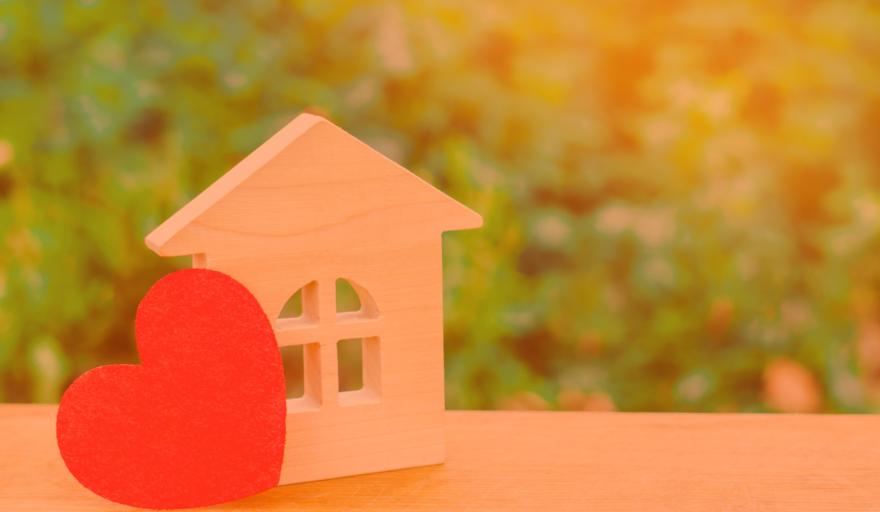 Picture of a small wooden house sitting next to a heart