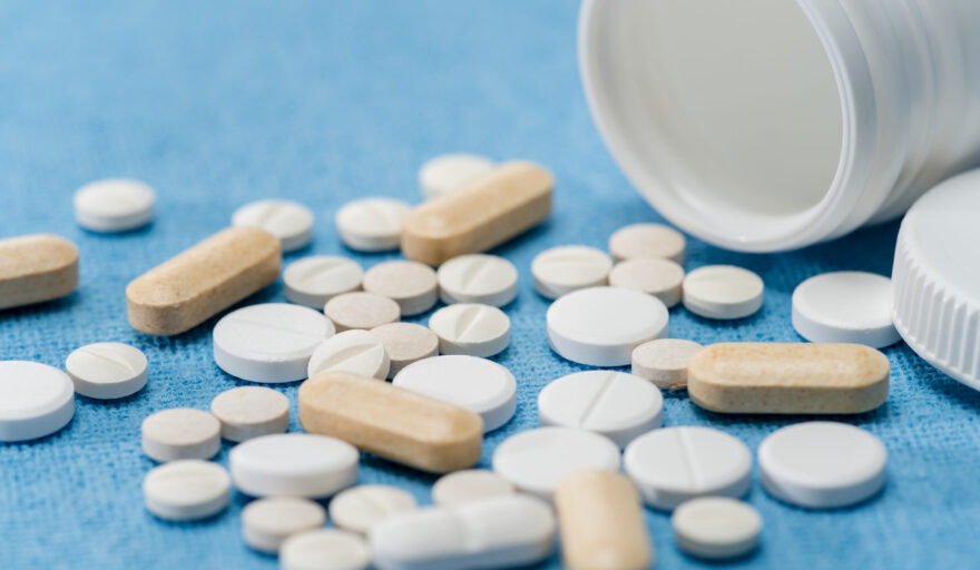 various pills spilled on blue background